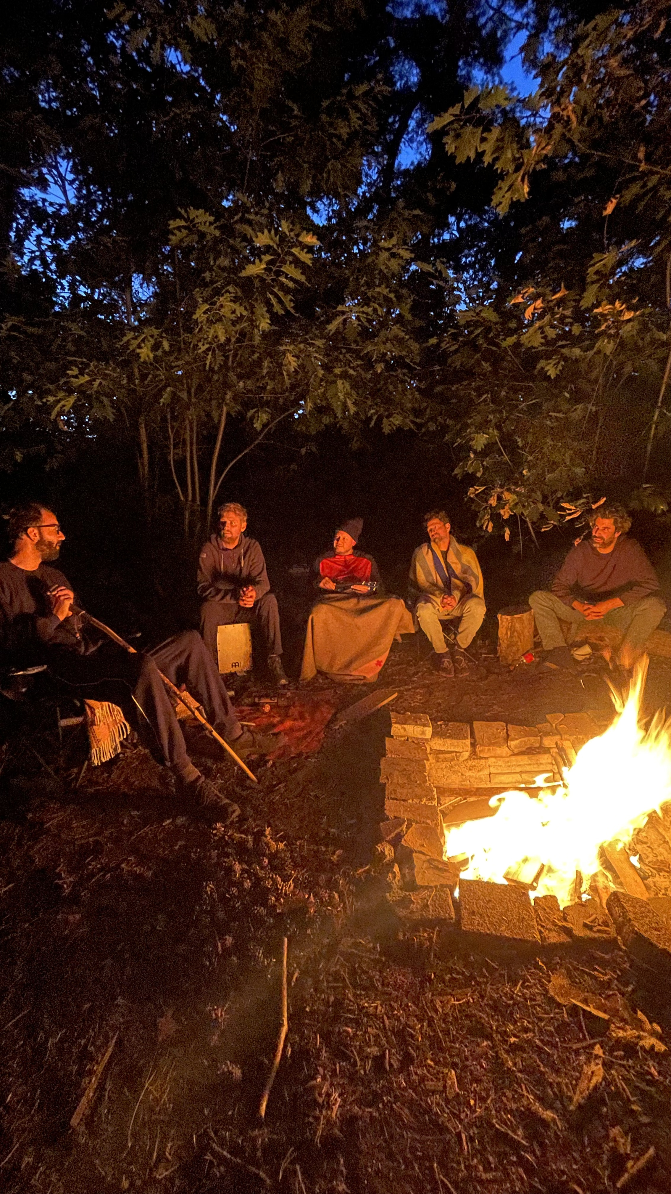 Mannen van de MANA community rond een vuur
